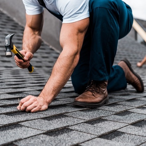 professional nailing down shingle roofing